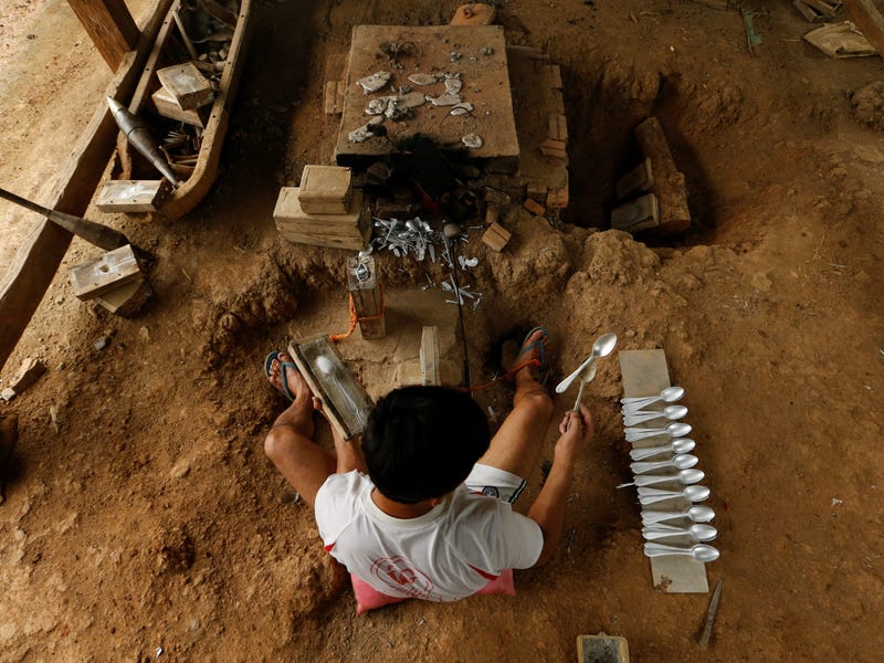 Một người đàn ông làm ra những chiếc thìa bằng cách làm tan những quả bom do máy bay của Không quân Mỹ ném xuống trong Chiến tranh Việt Nam, tại làng Ban Napia, tỉnh Xiêng Khoảng, Lào