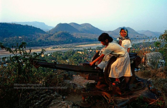 Trẻ em chơi đùa trên ụ súng phòng không sót lại từ thời chiến trên đồi Phou Si, ngọn đồi thiêng ở trung tâm thành phố cổ Luang Prabang.