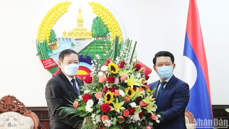Đại sứ Nguyễn Bá Hùng tặng hoa chúc mừng Phó Thủ tướng, Bộ trưởng Ngoại giao Lào Saleumsay Kommasith và Bộ Ngoại giao Lào. (Ảnh: TRỊNH DŨNG)